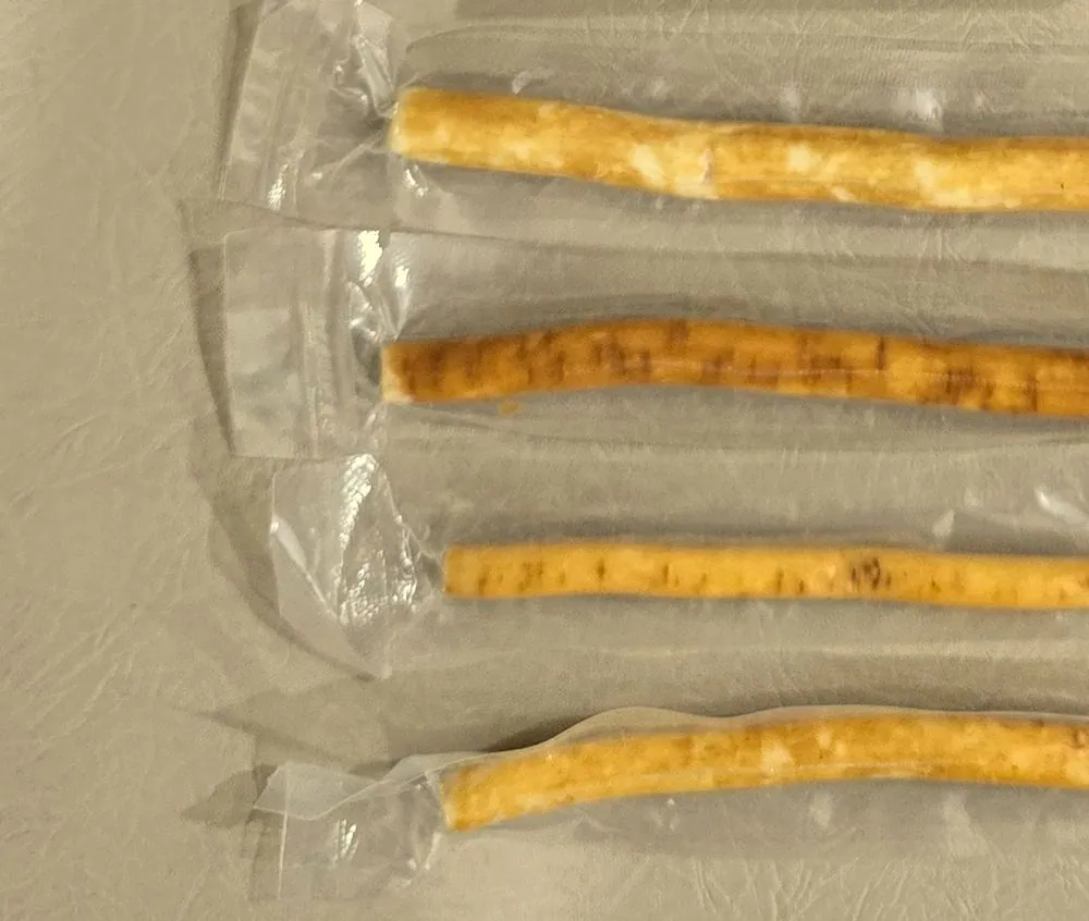 Sealed miswak sticks stacked in rows, supplied without retail packaging